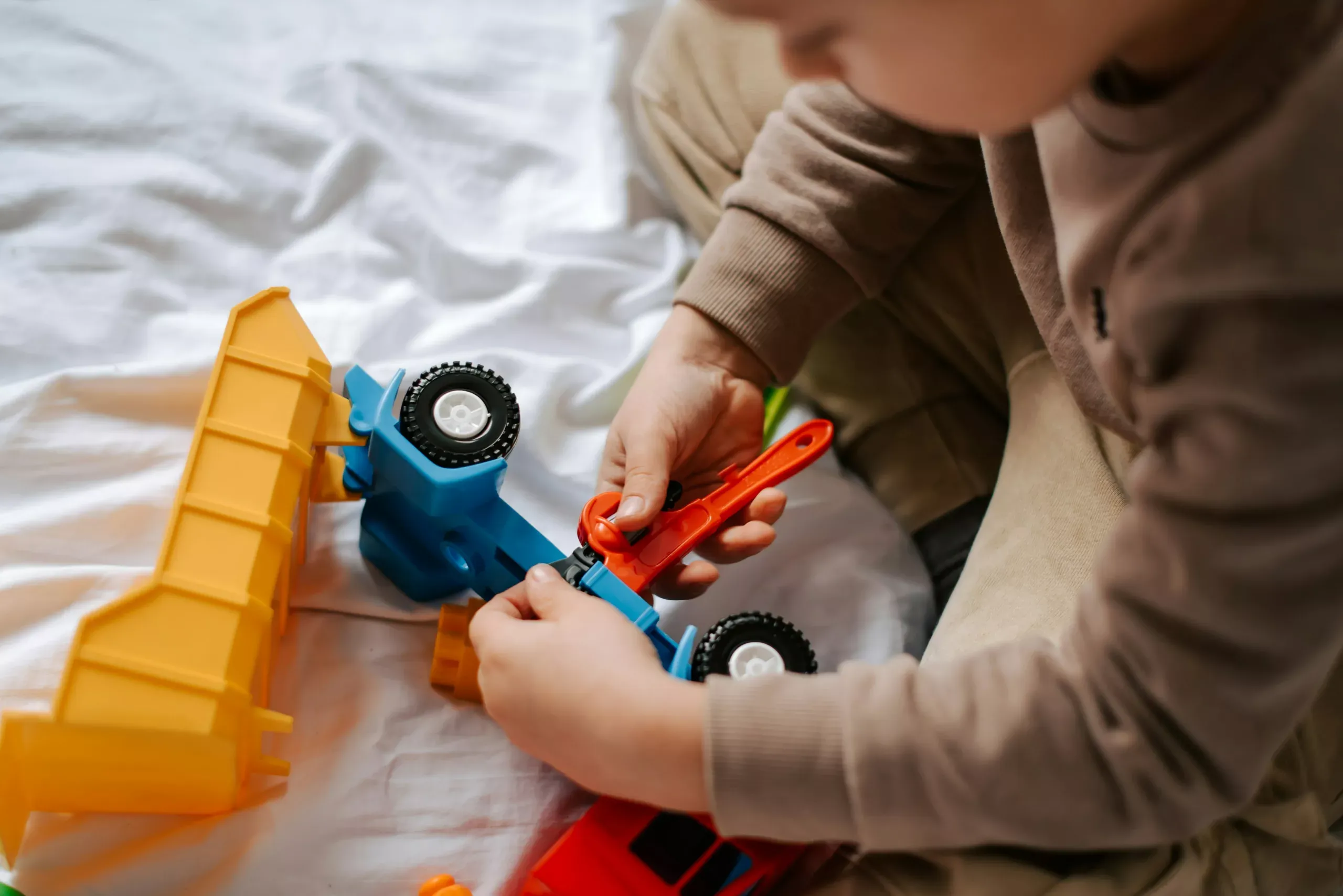 A child playing with a toy truck to illust